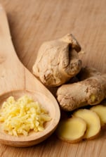 Close up of different forms of ginger against a wood worktop.jpeg